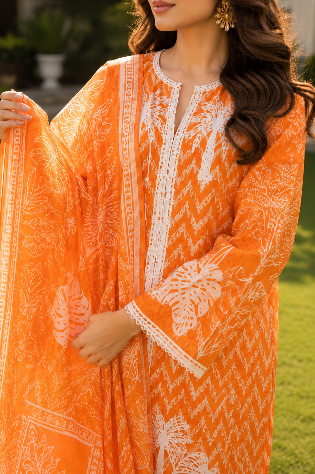 Close-up sleeve view of Aftaab orange lawn suit highlighting printed sleeve design and cuff details
