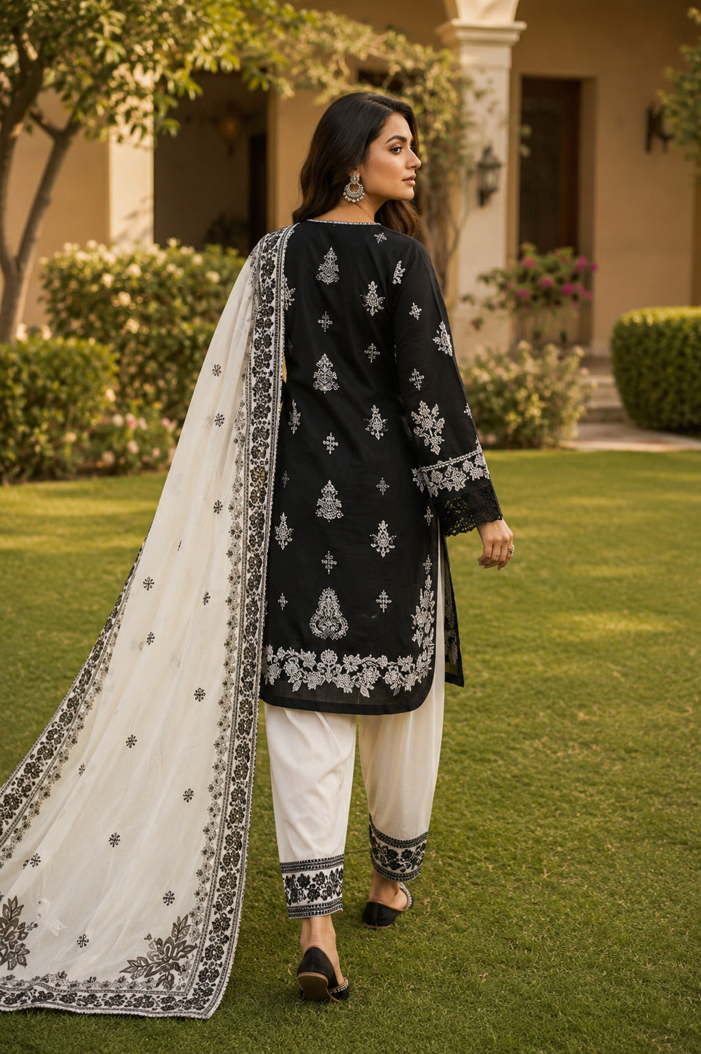 Roshni Approved Black & White Pakistani Lawn Suit Back View with Embroidered Dupatta in Luxury Garden Setting