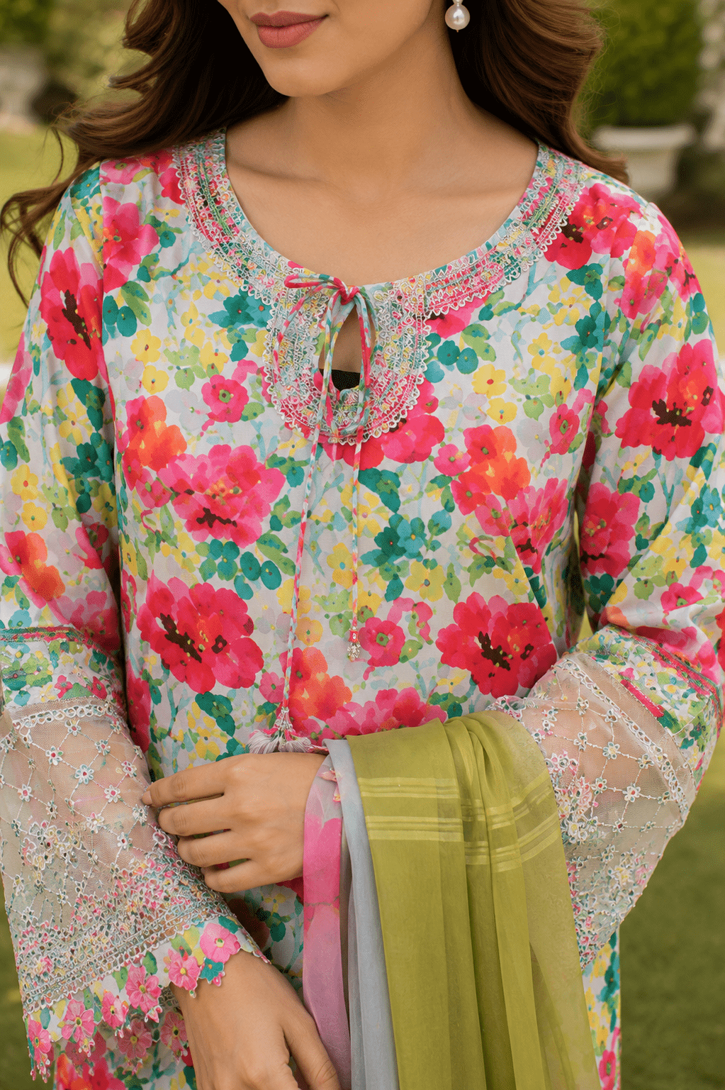 Pakistani women's floral lawn suit sleeve close-up showing intricate lace border embroidery and premium fabric texture