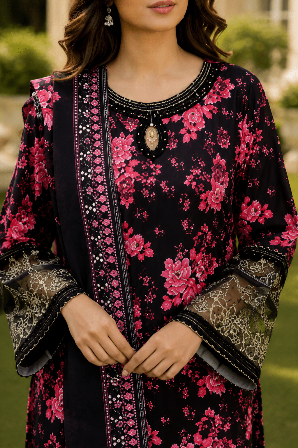 Close-up sleeve detail of black and pink floral Pakistani lawn suit showcasing embroidered cuffs, lace finishing, floral print and premium fabric craftsmanship.