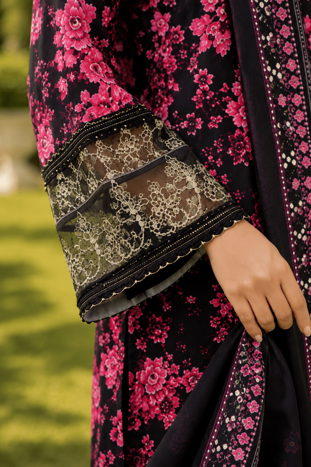 Close-up front detail of black and pink floral Pakistani lawn dress featuring embroidered neckline, premium fabric texture, printed design and luxury fashion styling.