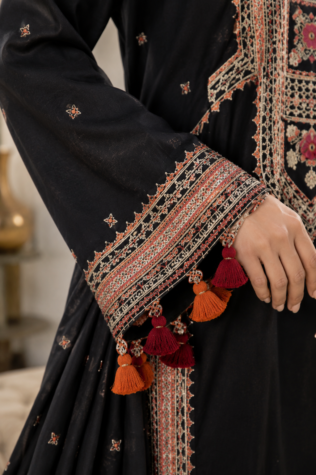 Close-up sleeve detail of black embroidered lawn suit showcasing intricate embroidery, tassels, lace finishing and premium craftsmanship
