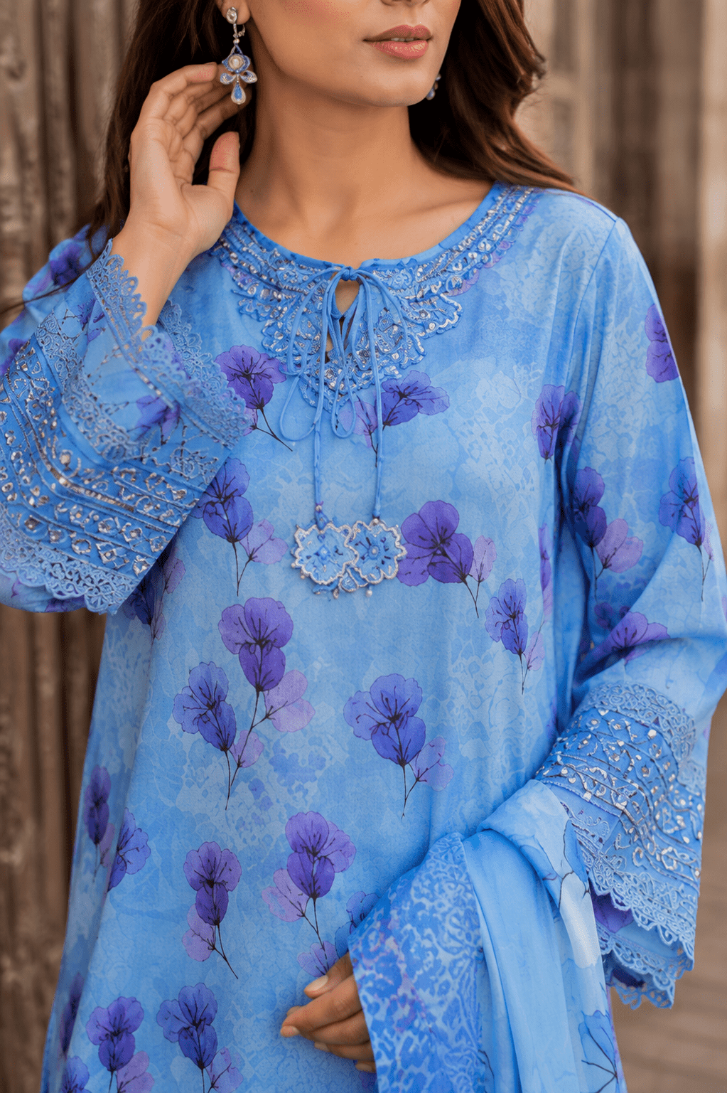 Close-up front detail of sky blue floral printed Pakistani lawn suit featuring embroidered neckline, tassel details and premium fabric texture