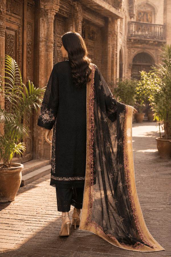 Back view of black embroidered Pakistani lawn suit with floral printed chiffon dupatta, luxury women's ethnic wear photographed in Old Lahore heritage street.