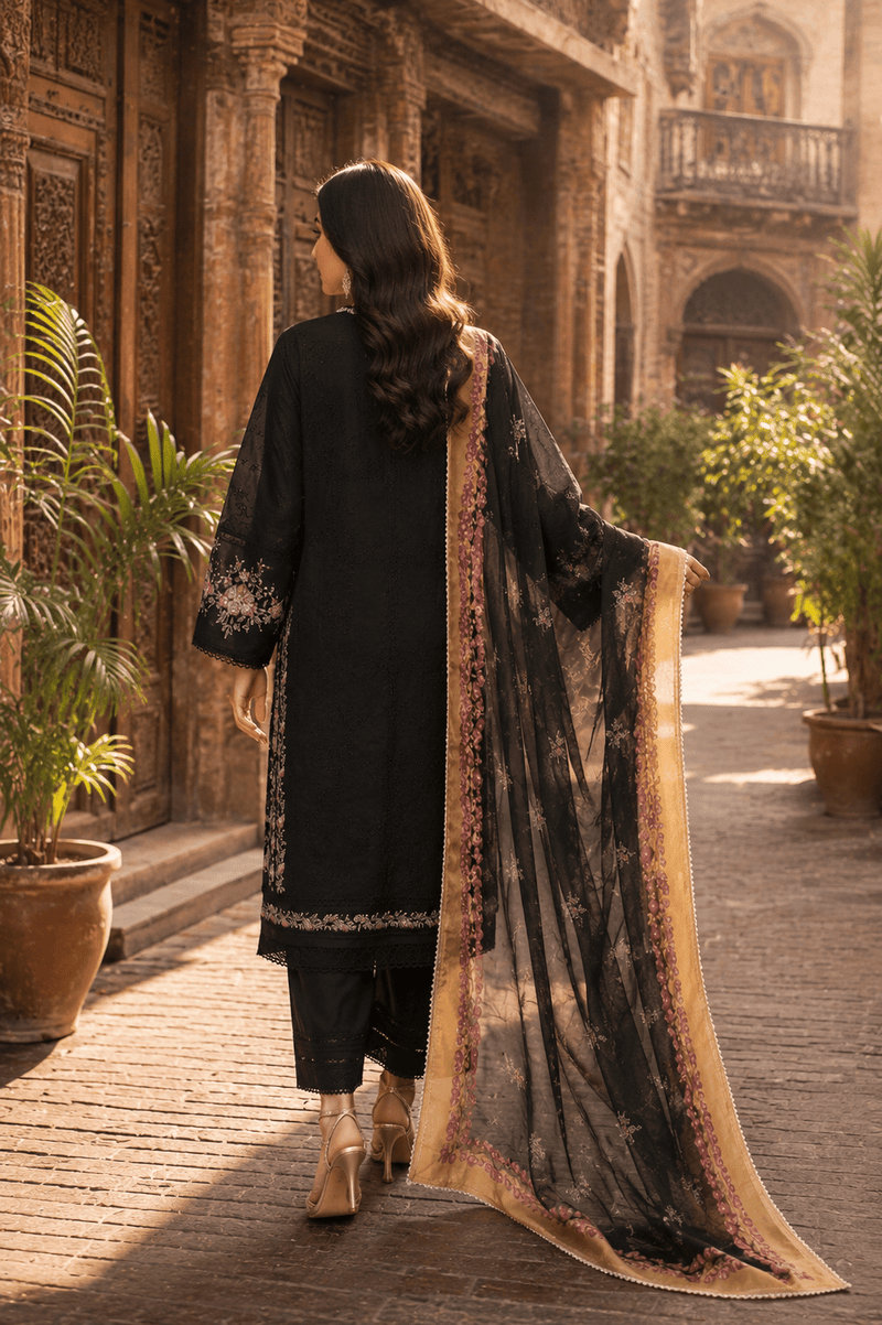 Back view of black embroidered Pakistani lawn suit with floral printed chiffon dupatta, luxury women's ethnic wear photographed in Old Lahore heritage street.