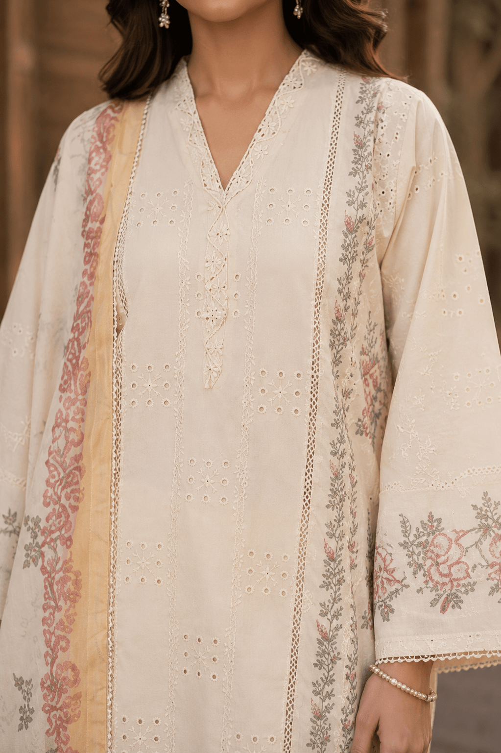 Close-up front panel and neckline of off white embroidered Pakistani lawn shirt featuring lace details, premium stitching and delicate floral prints.