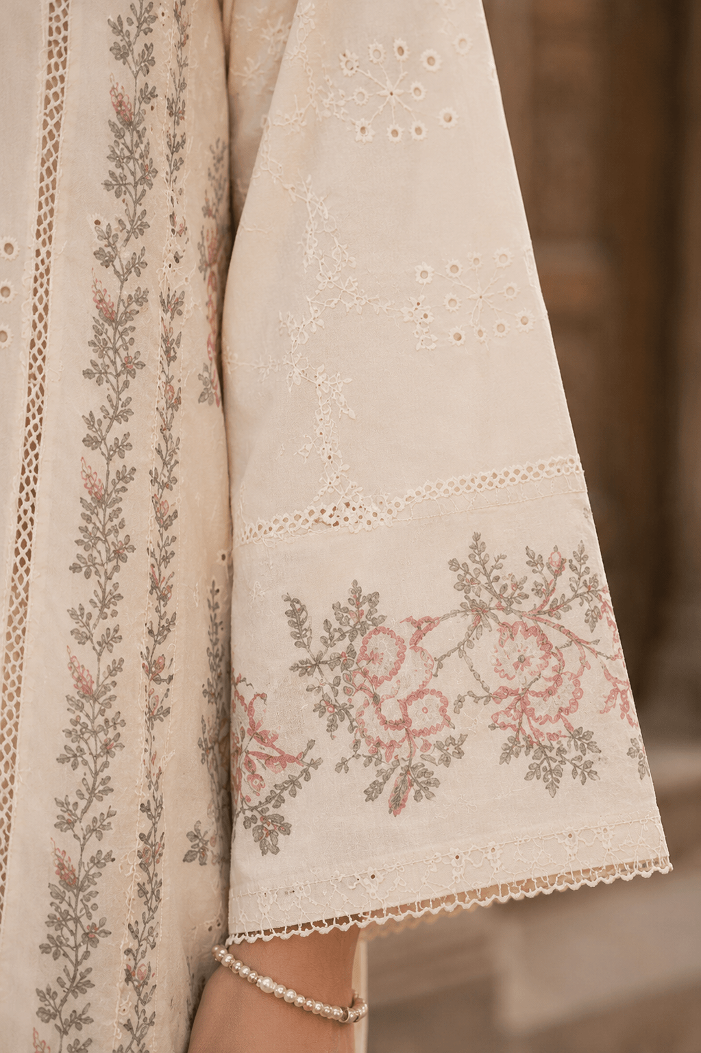 Close-up sleeve embroidery and lace cuff detail of off white Pakistani lawn suit showcasing premium fabric texture and craftsmanship.