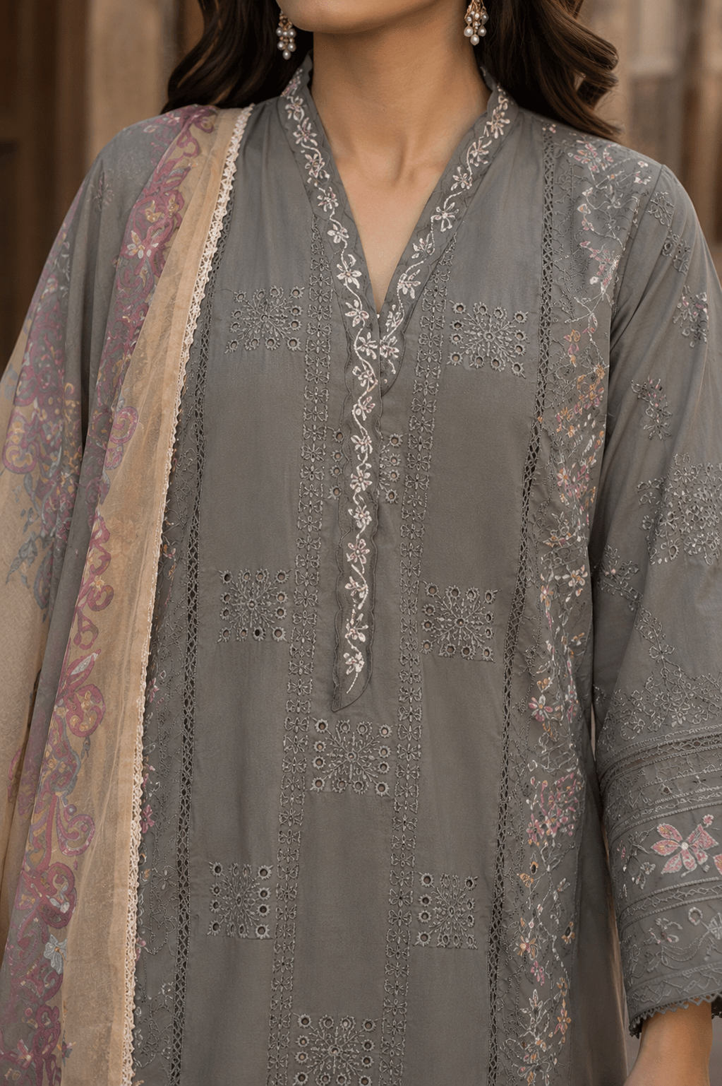 Close-up neckline and front embroidery detail of grey Pakistani lawn suit featuring lacework, premium stitching and elegant craftsmanship.